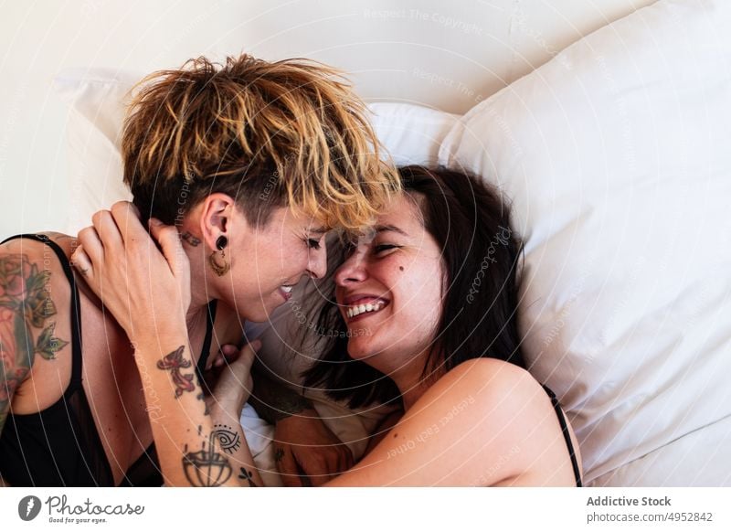 Lovers in Underwear Hugging and Kissing in Bedroom Stock Photo