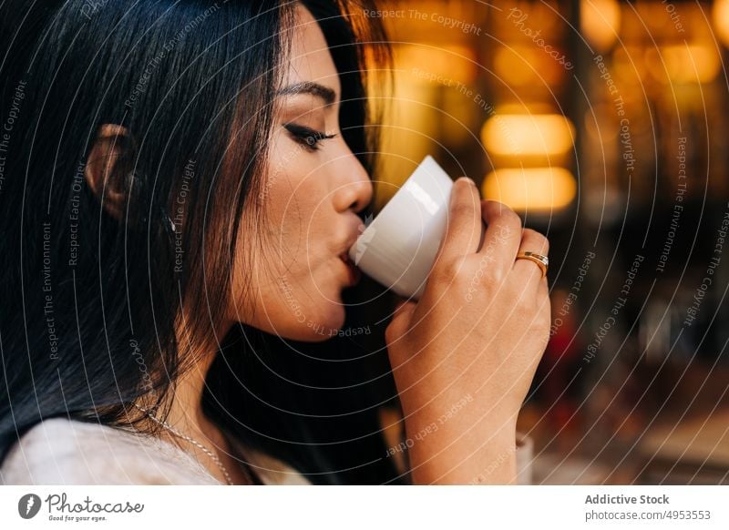 Crop Asian woman enjoying coffee in cafeteria drink delicious aroma beverage hot drink cup coffee house feminine natural idyllic alone fragrant ceramic material