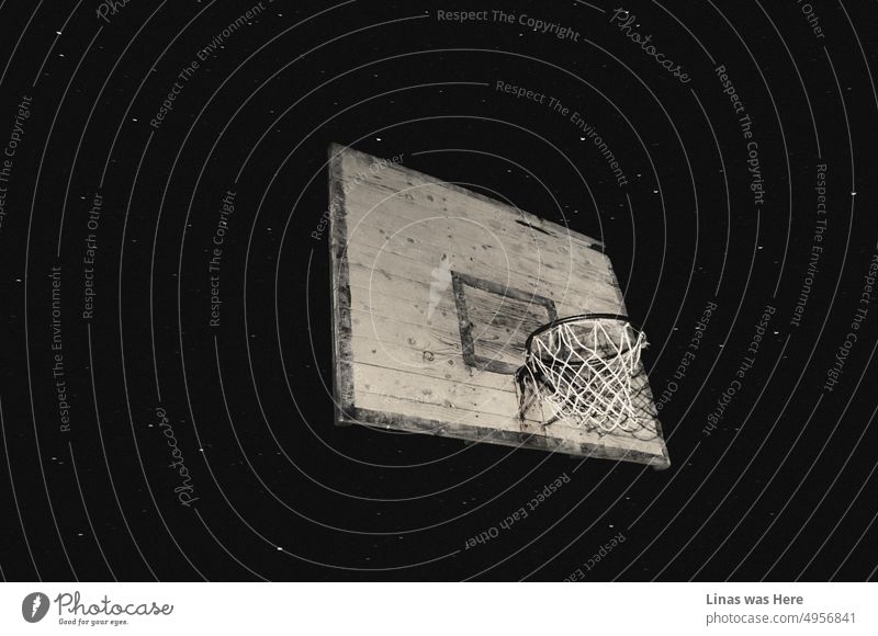 An image of a rustic basketball hoop. With a starry sky as a background. A summer night and a creative picture of a vintage metal hoop. Abandoned sports.