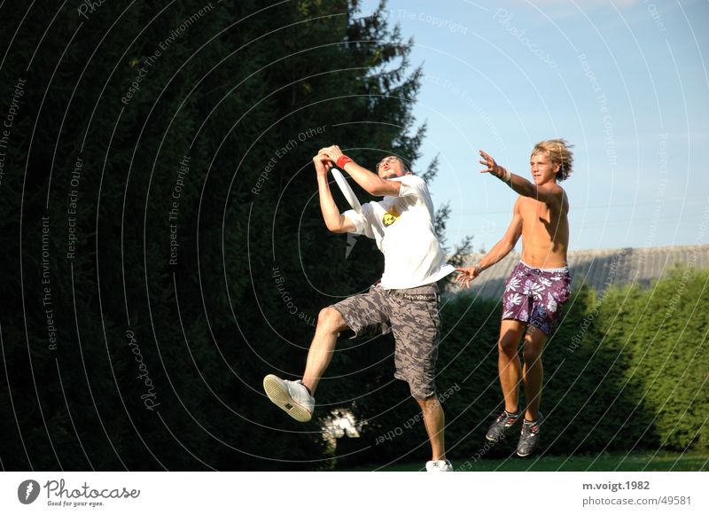 Ultimate Frisbee Colour photo Exterior shot Copy Space left Life Leisure and hobbies Young man Youth (Young adults) Man Adults 2 Human being Movement Fight Jump