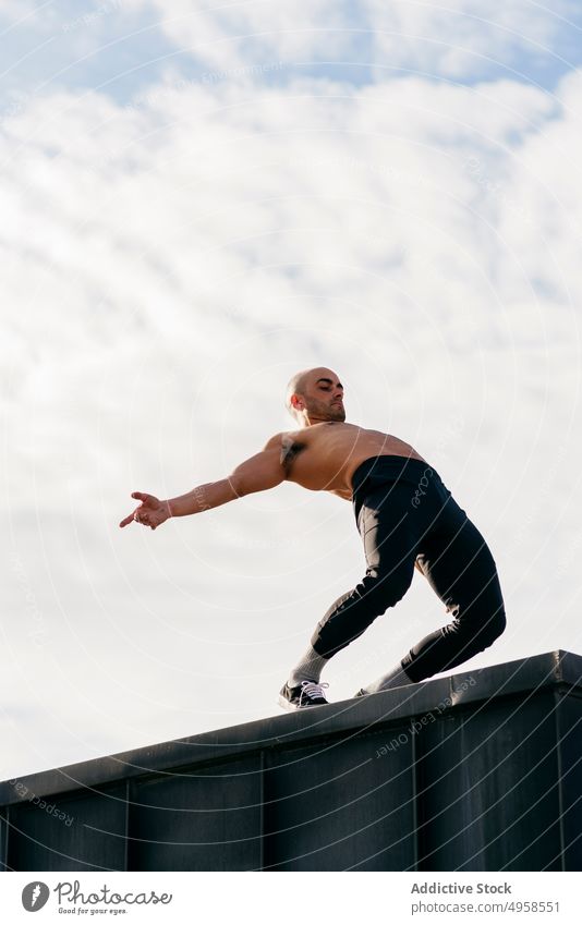 Athletic man doing parkour exercises outdoors person balance performing sport young action athlete trick fitness city street active healthy athletic sportive