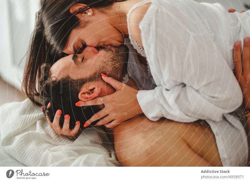 Young beautiful couple having hugging and kissing at home family bed indoors love relaxation woman bedroom people affection adult embrace romance apartment