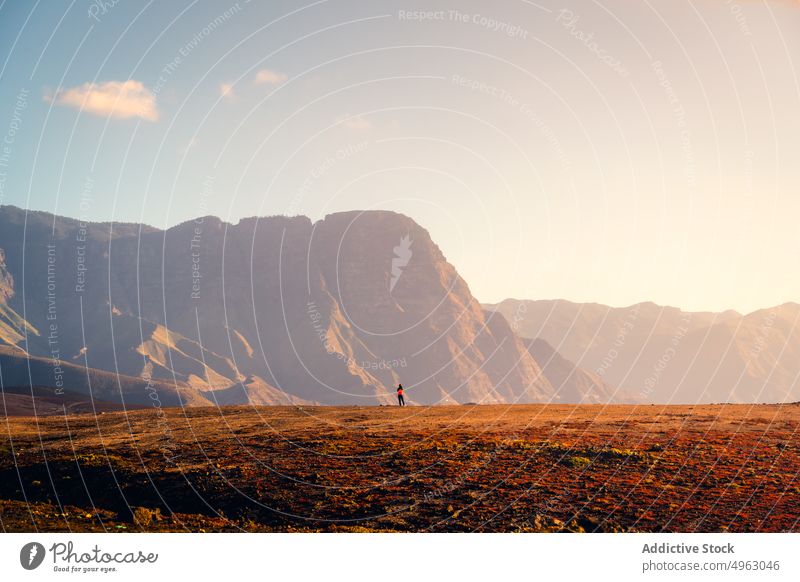 Anonymous traveler standing along seashore in mountains woman sunset coast highland rocky explorer walk gran canaria canary islands stroll nature sky beach