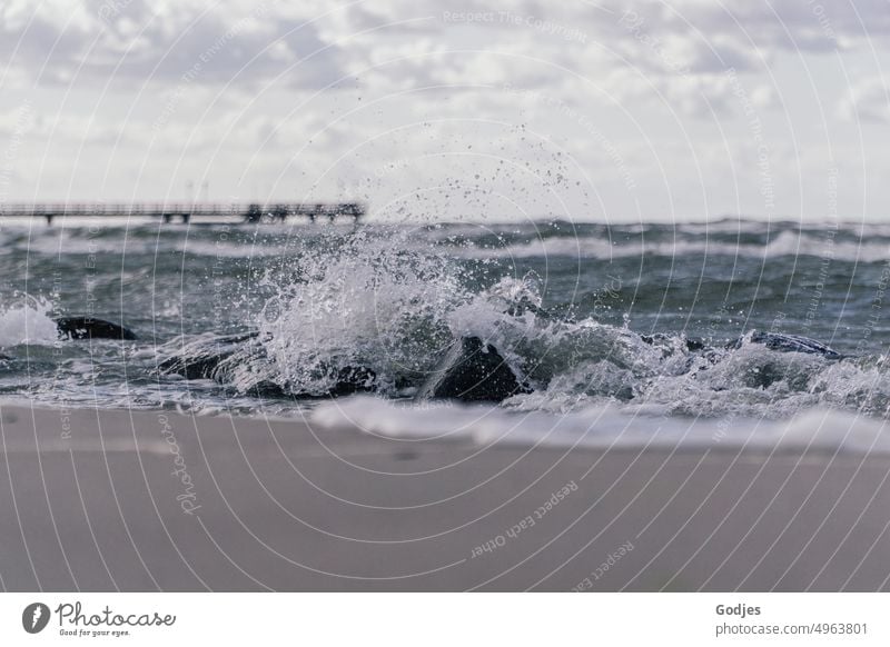 Wave breaks on stones on beach wave White crest Beach Baltic Sea Sky Clouds stormy Footbridge Ocean Water coast Waves Nature Gale Landscape Blue Colour photo