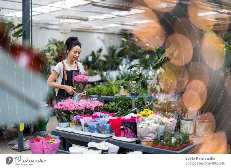 Florist at the flower shop, taking care of plants plant nursery smiling positivity nature garden gardening cultivate growth hobby freshness growing flora green