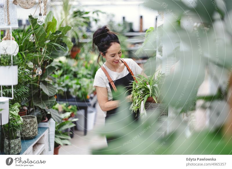 Florist at the flower shop, taking care of plants plant nursery smiling positivity nature garden gardening cultivate growth hobby freshness growing flora green