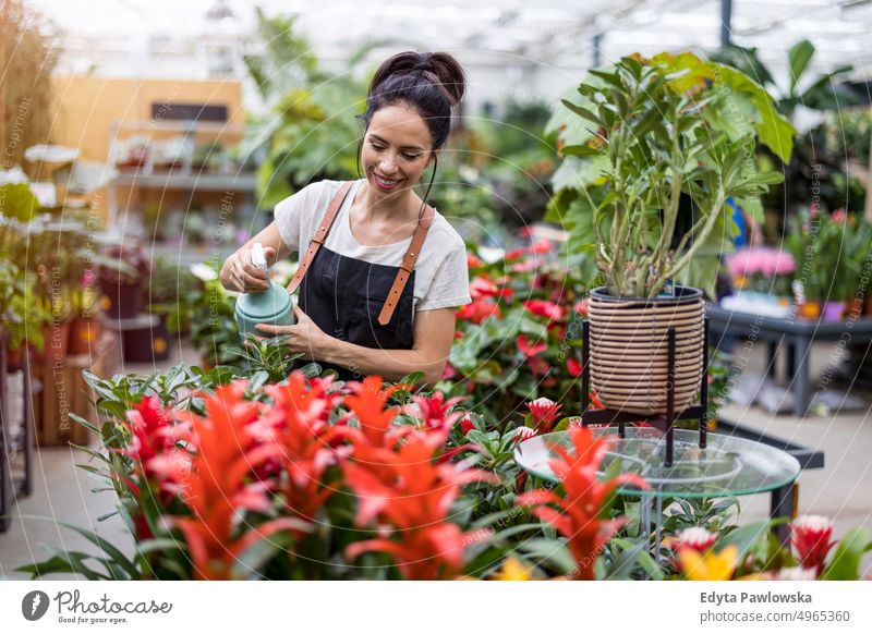 Shot of a young woman working with plants in a garden centre plant nursery smiling positivity nature gardening cultivate growth hobby freshness growing flora