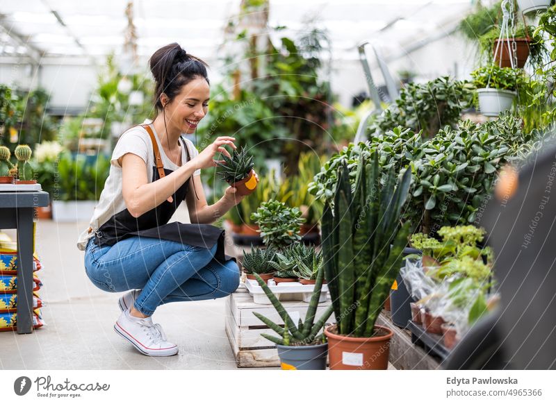 Florist at the flower shop, taking care of plants plant nursery smiling positivity nature garden gardening cultivate growth hobby freshness growing flora green