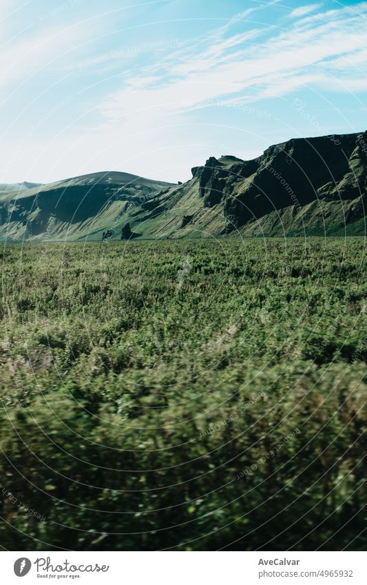Massive green mountain on Iceland. View from the road during a trip through Icelandic wild areas. Boho backpacking traveling style, nature background concept. Colorful scenario