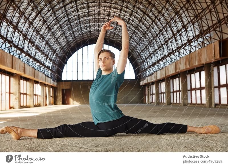 Talented young ballet dancer performing splits in hall talented graceful flexible empty stretching man male athlete performer handsome attractive slender