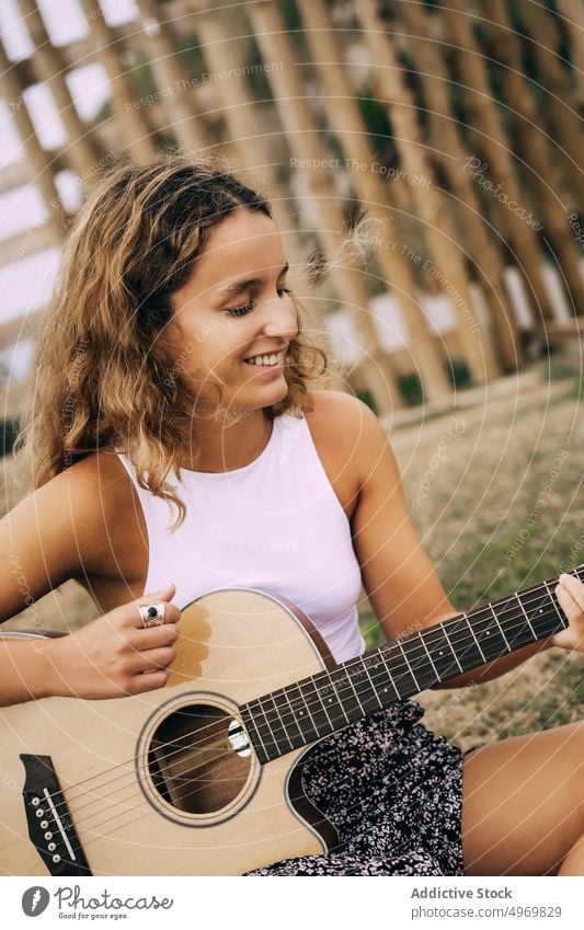 Woman playing guitar in field with dry vegetation music woman romantic young instrument cheerful female musical fun vacation fashion holiday casual summer