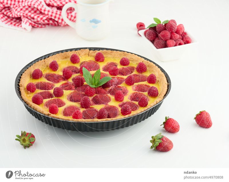 Round quiche with red strawberries and raspberries on a white table pie cake cream food baked fresh round dessert pastry cookery meal homemade slice sweet piece