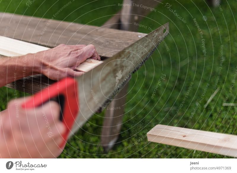 Man saws through a board Saw Craft (trade) Craftsperson Wood Tool Work and employment Home improvement Build Wooden board Hand Profession Joiners workshop