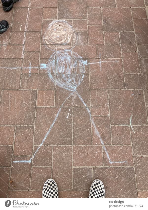 Feet of young man with checkered shoes and chalk drawing photographed from above feet Footwear vans Man Chalk drawing Shadow