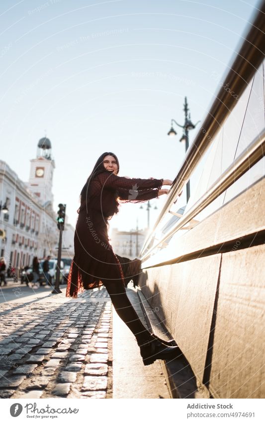 Portrait of young woman at Puerta del Sol in Madrid hanging handrail puerta del sol city madrid beautiful happy attractive vacation female pretty urban tourist