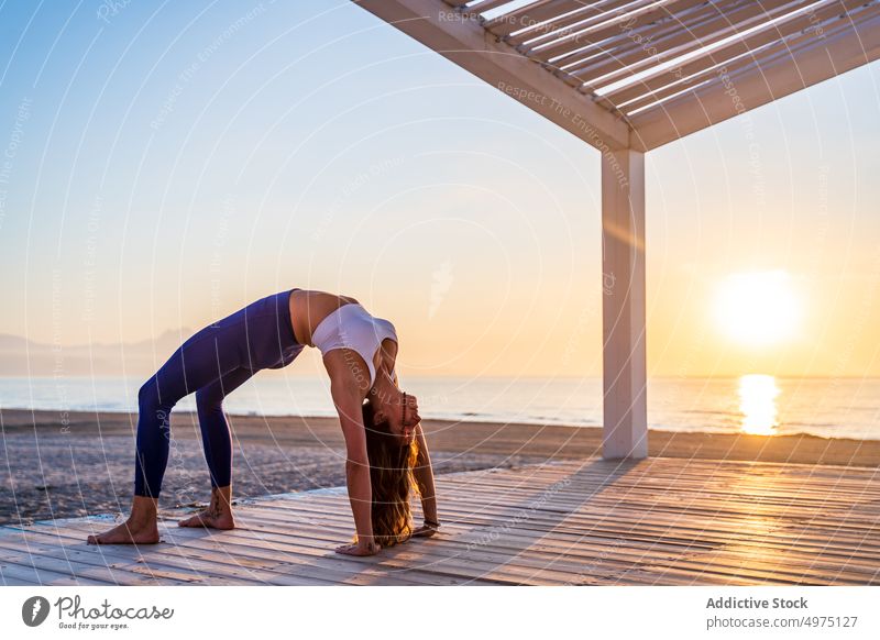 Woman doing boat yoga pose on the beach stock photo (238147