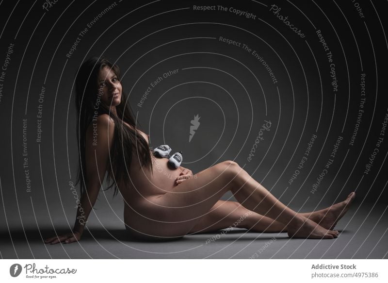 Nude pregnant woman with shoes on belly nude expect maternal motherhood pregnancy happy female naked love tummy baby care smile await touch tender brunette