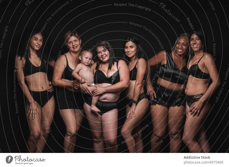 Positive multiracial women in underwear with baby - a Royalty Free