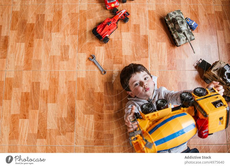 Fashionable boy holding a toy car in his hands, isolated on a white studio  background. A handsome child dreaming of a real car. Dreams of a child  about racing. 26460318 Stock Photo