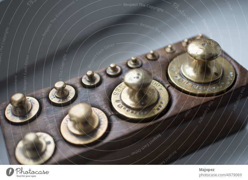 Set of traditional weights in a wooden box seen from above collection industrial design industry metallic iron antique background big bright challenge close up