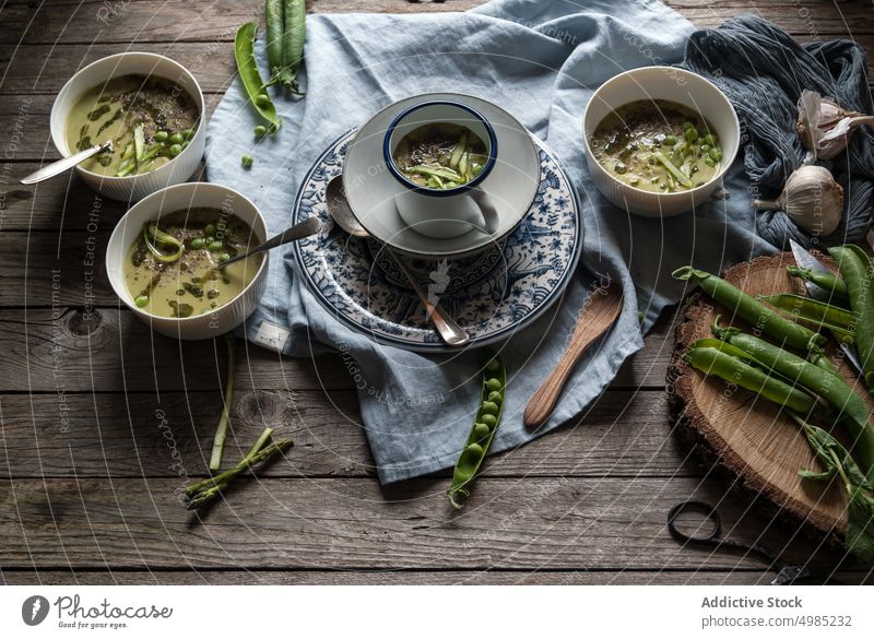 Composition of soup bowls and pea pods composition rustic green gourmet natural cooking eating vegetable served view vegan organic coconut cream design layout