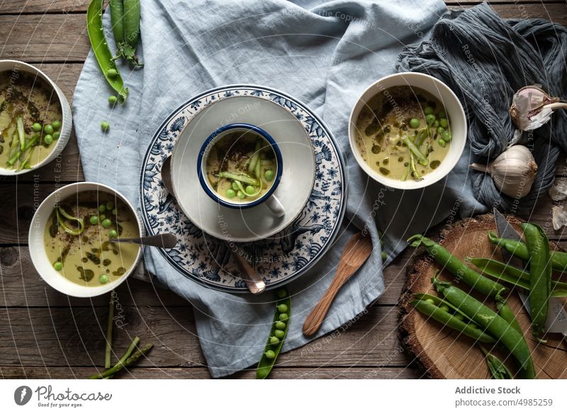 Composition of soup bowls and pea pods composition rustic green gourmet natural cooking eating vegetable served view vegan organic coconut cream design layout