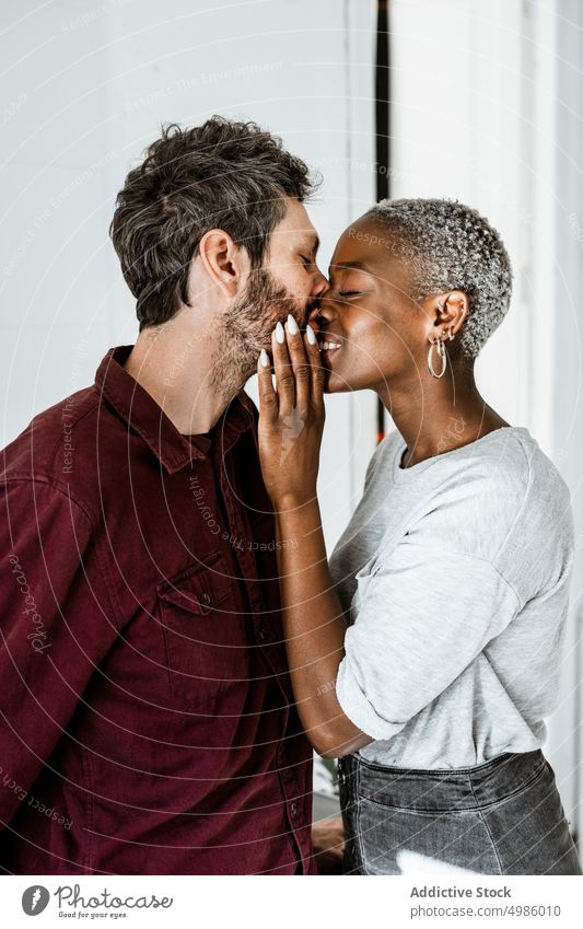 Happy couple cuddling in modern room love hug home embrace cuddle relationship smile laugh enjoy casual together romantic affection multiethnic african american