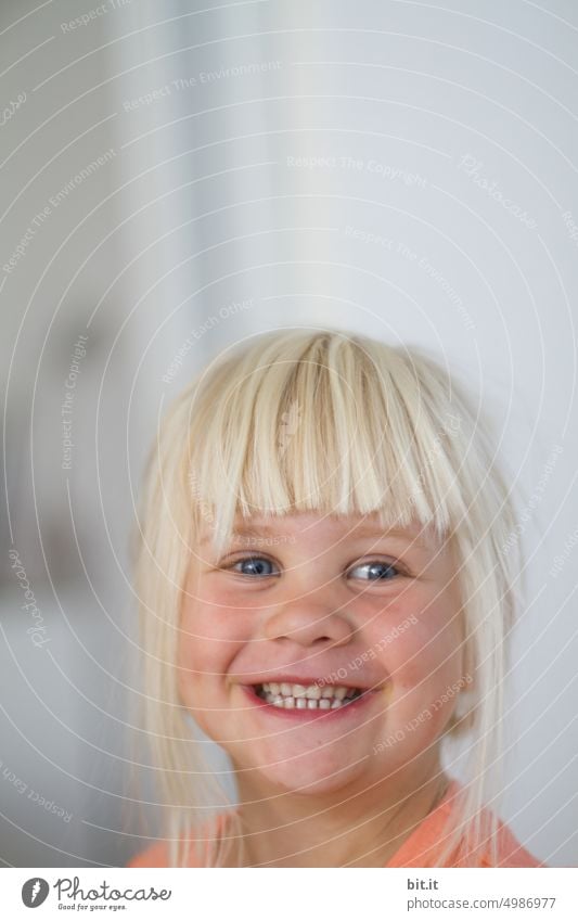 Natural blonde girl on bright neutral background, laughing into camera. Child, girl with bright eyes. Funny, witty portrait. Childhood, happiness, cheerfulness, humor. Beautiful childhood. Child, teeth, mouth. Cheeky, mischievous joker.