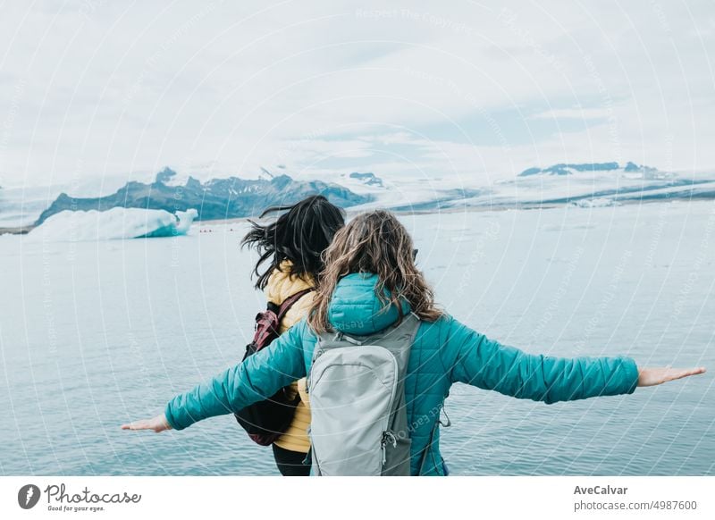 Young woman couple of travelers at the vatnajokull glacier having a fun day exploring Iceland. person iceberg glacial hike hiking lagoon young active arctic