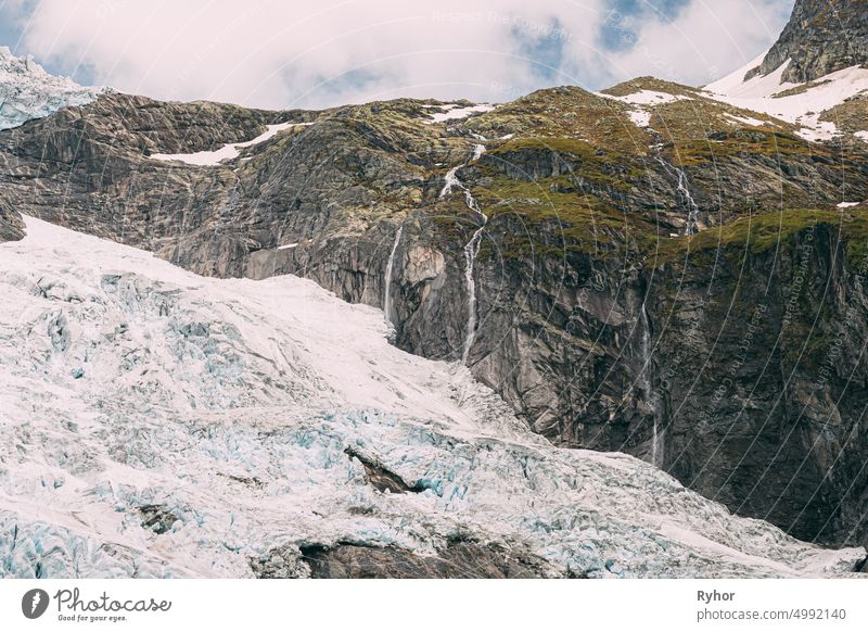 Jostedalsbreen National Park, Norway. Close Up View Of Melting Ice And Snow, Small Waterfall On Boyabreen Glacier In Spring Sunny Day. Famous Norwegian Landmark And Popular Destination. Close Up