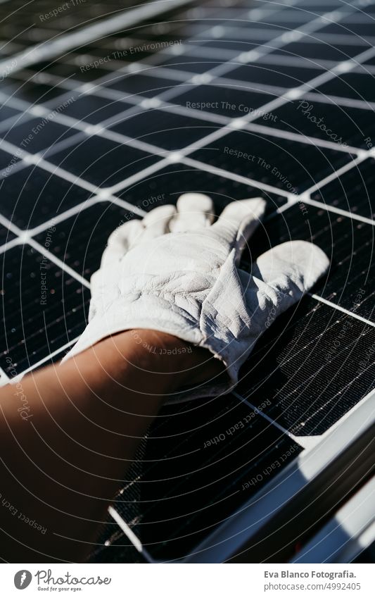 hand of mature Technician man touching solar panels on house roof for self consumption energy. Renewable energies and green energy concept drill technician