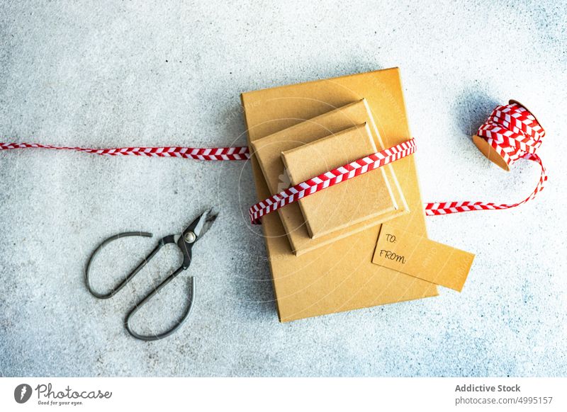 Christmas gift box with background christmas concrete decor decoration festive holiday present red ribbon rustic scissors seasonal stack stacked tag vintage