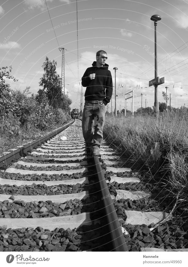 railway walker Railroad Man Masculine Railroad tracks Exterior shot Sunglasses Black White Meadow Posture Sweater Train station Cool (slang) Sky Jeans
