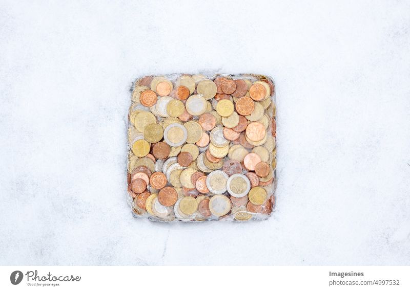 Frozen. Money in the ice in the winter in the snow. Euro coins, cash frozen. Euro assets frozen and the concept of financial crisis quick-frozen Ice Winter Snow