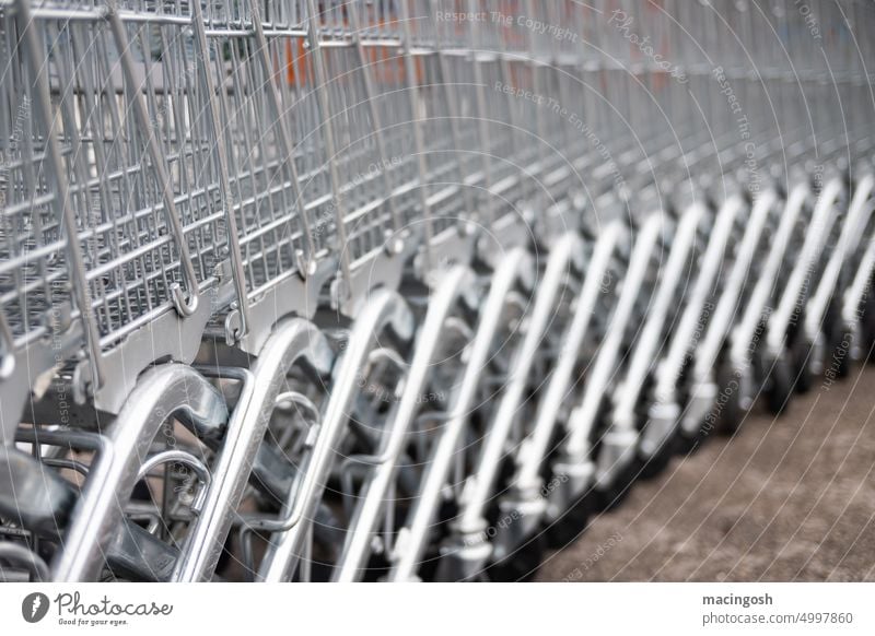 Long row of empty shopping carts Shopping Trolley trolley Supermarket Consumption Shopping basket Metal Deserted Trade Colour photo Retail sector Empty Markets