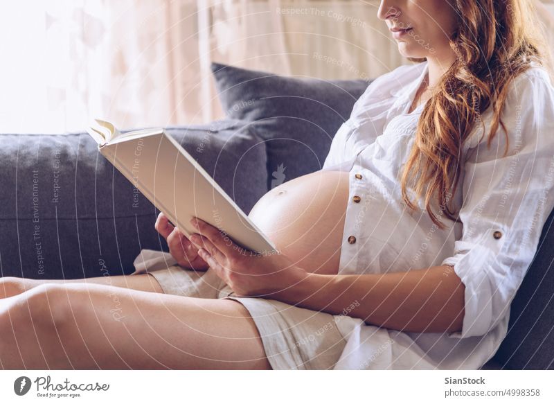 Pregnant caucasian woman relaxing at home. Young expectant mother strokes  her pregnant belly and thinks about the baby childbirth. - a Royalty Free  Stock Photo from Photocase