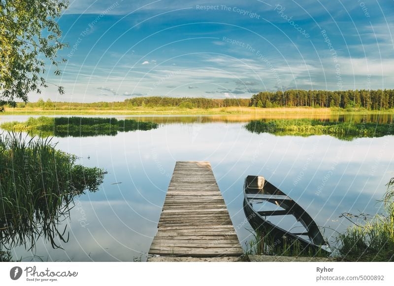 Old Wooden Fishing Boat Near Pier In Summer Lake Or River. Beautiful Summer Sunny Day Or Evening. Forsaken Boat. Russian Nature abandoned beautiful belarus boat