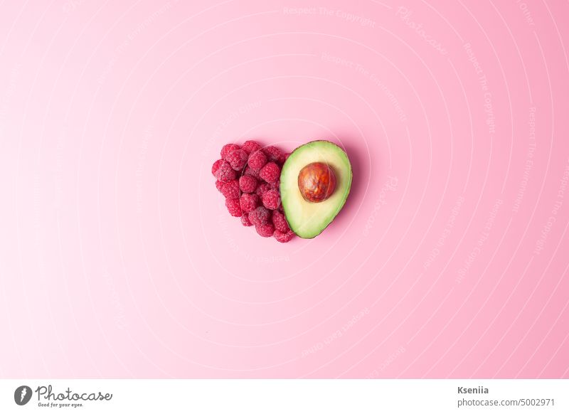 Creative summer concept. Heart shape made from fresh berries and avocado on pink background. Flat lay, copy space. bio breakfast cooking culinary detox diet