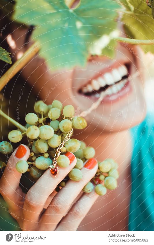 Woman with grape in garden woman vine bunch fruit touch summer fresh cheerful vineyard green nature female smile growth lush organic season rural harvest