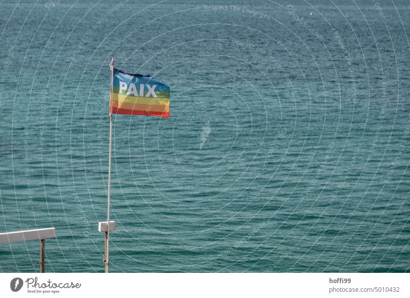 PAIX - Peace on rainbow flag with blue sea in background Rainbow Rainbow flag paix Tolerant Symbols and metaphors Love Flag Equality Freedom variety Pride