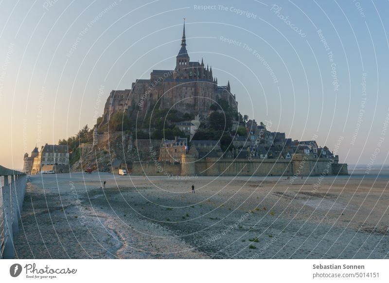 Le Mont Saint Michel at sunset during low tide on a summer evening seen from the bridge, Normandy, France abbey town france normandy mont saint michel landmark