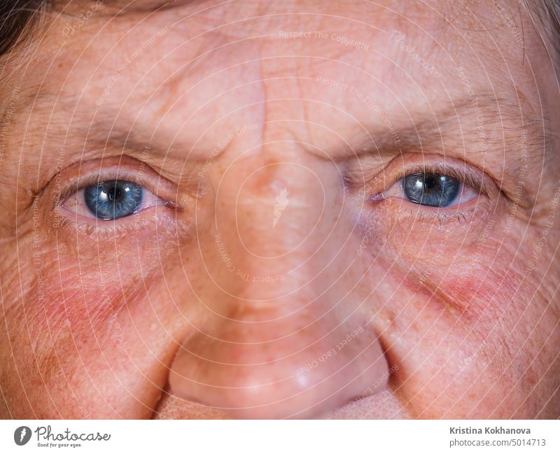 Contraction of the pupil. Beautiful blue eyes iris of middle-aged woman. Peepers of old grandmother with wrinkles. beautiful closeup cornea eyeball eyebrow