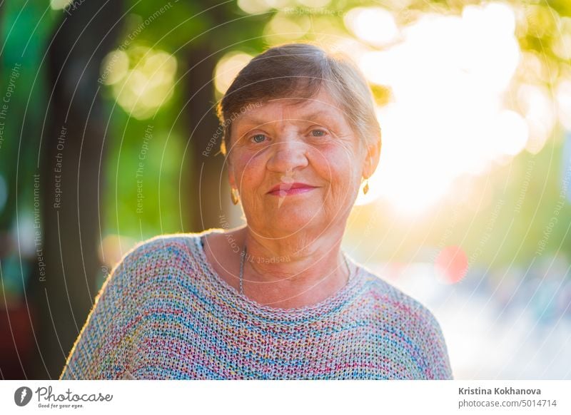 Beautiful portrait of smiling aged woman on the summer street. Caucasian grandmother looking at camera elder grandma happiness adult caucasian face female human