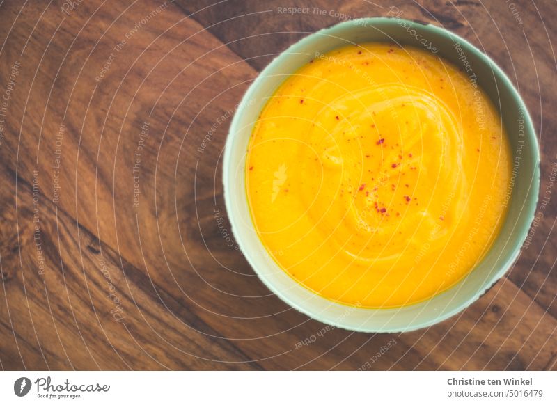 Warming pumpkin soup in a bowl stands on the wooden table Pumpkin soup shell Vegetarian diet soup bowl Nutrition vegetarian vegan Food Fresh home-cooked