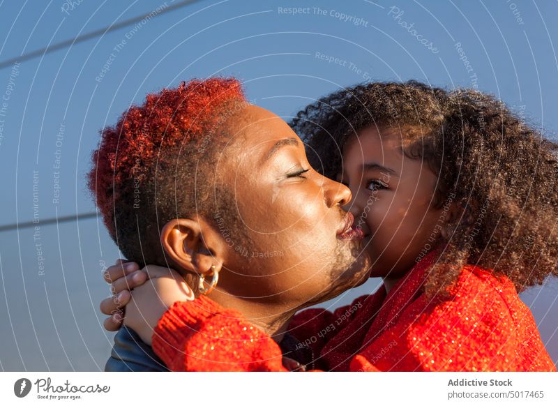 Smiling cute black girl holding black child on street mother step sunshine woman smiling cheerful daughter stair sunny day african american happy positive walk