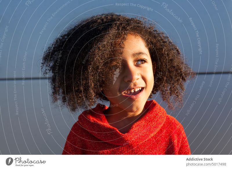 Smiling cute black girl on street sunshine smiling cheerful child step sunny day african american happy positive walk city town hairdo hairstyle female kid