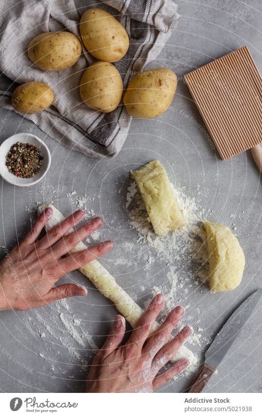 Crop person rolling potato dough for pasta cook gnocchi table kitchen pepper flour prepare food ingredient process fresh recipe cuisine raw culinary meal