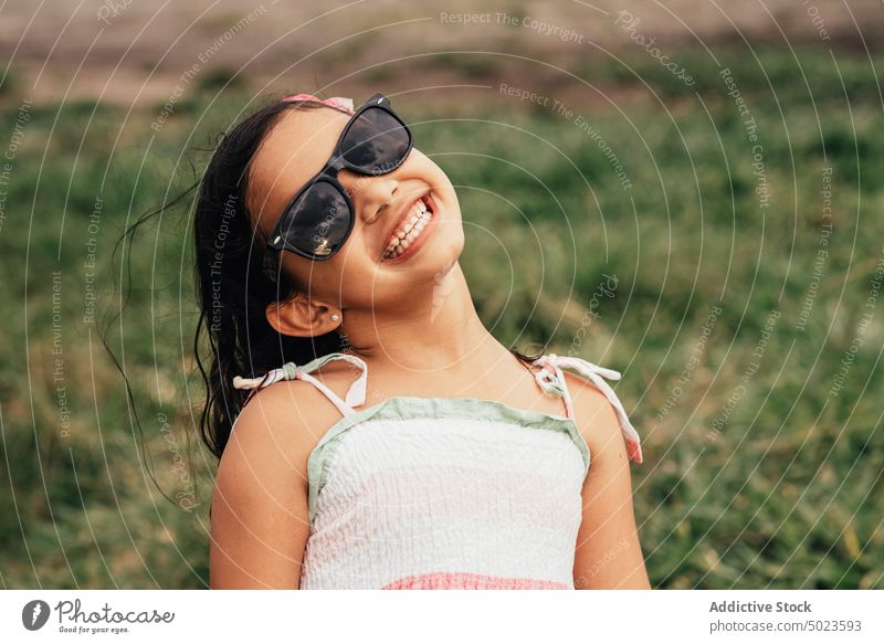 Optimistic girl in sunglasses in field smile summer rest weekend style grass port