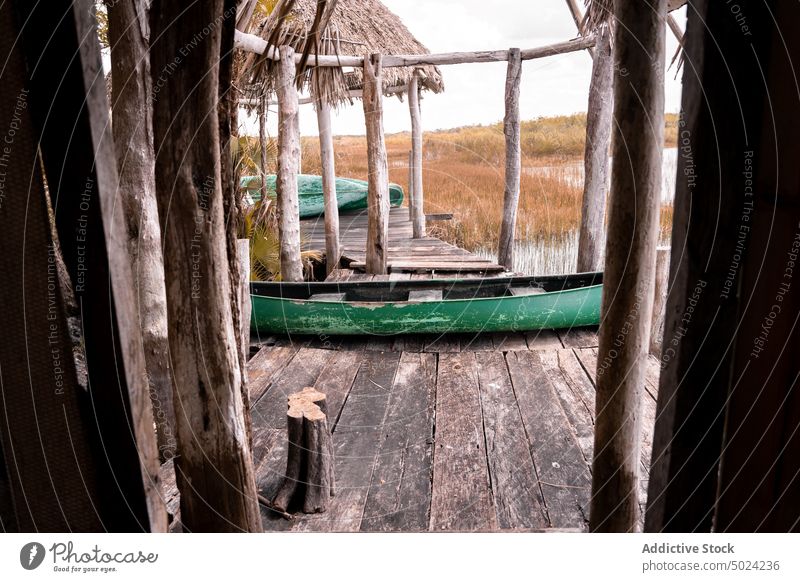 Shabby boat on wooden pier in village countryside river quay shabby old rustic rural water weathered timber lumber vessel summer aged grunge tranquil calm