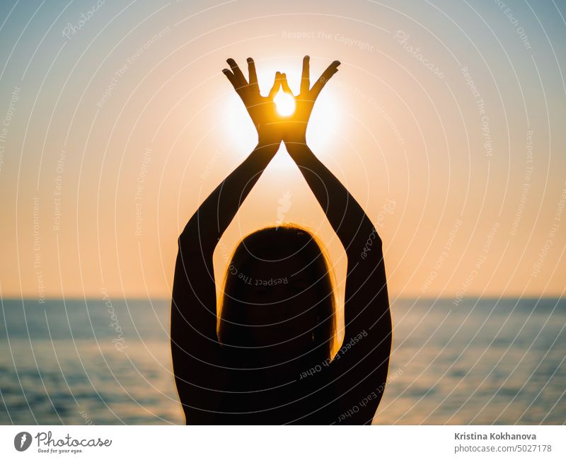 Woman's hands symbolizing prayer and gratitude. Mudra. Yoga concept. Silhouette of female hands on sun background. Beautiful scene fitness meditation yoga